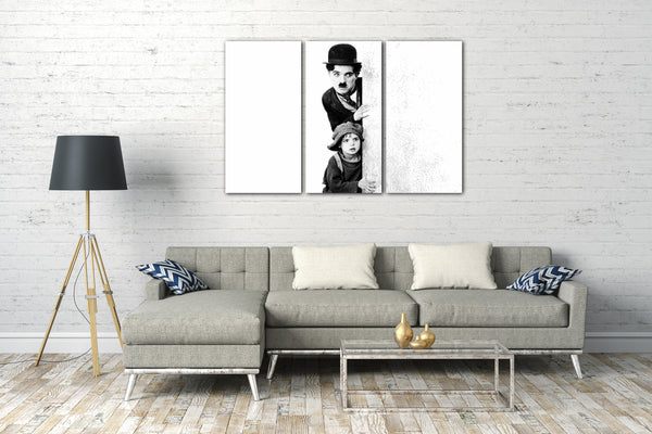 Leinwandbild Charlie Chaplin und kleines Kind hinter weißer Mauer-Wand