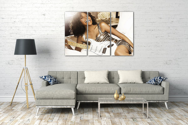 Leinwandbild Whitney Houston mit Gitarre auf dem Bett lachend sexy