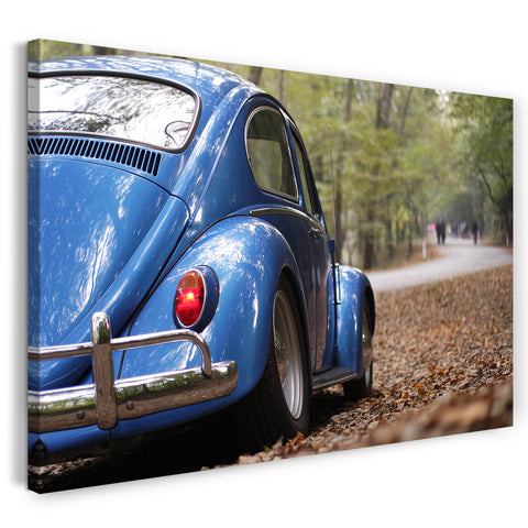 Leinwandbild Blaues Auto Käfer auf Waldstrße von hinten rechts