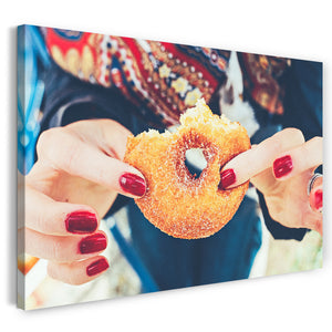 Leinwandbild Essensbilder Backwaren Frau zeigt angebissenen Donut