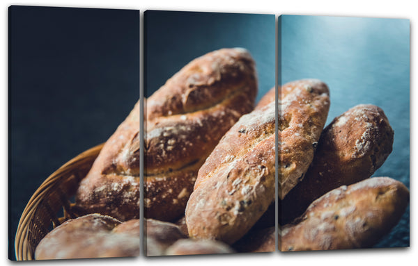 Leinwandbild Essensbilder Brotlaib 6 Stück in Korb vor blauem Hintergrund