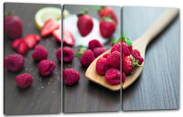 Leinwandbild Essensbilder Obst Früchte Himbeeren verteilt auf Holzlöffel und Tisch