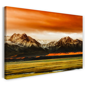 Leinwandbild Landschaftsbilder Gebirge vor grüner Weide unter rot schimmerndem Himmel