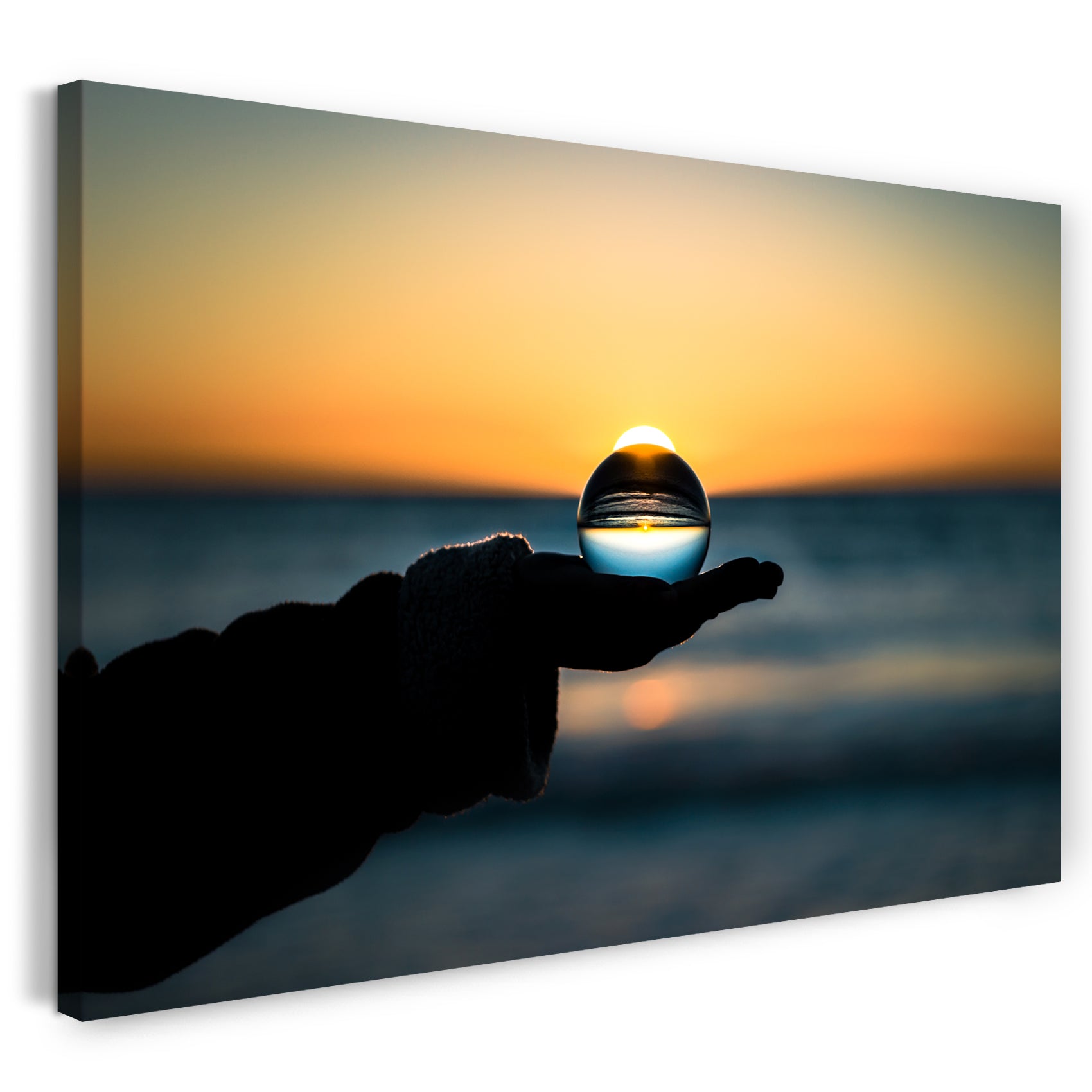 Leinwandbild Landschaftsbilder Glaskugel in Hand vor Meer und Sonnenuntergang