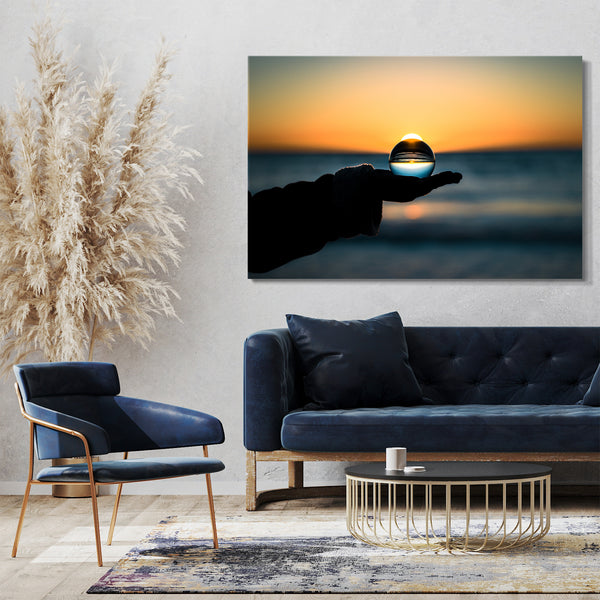 Leinwandbild Landschaftsbilder Glaskugel in Hand vor Meer und Sonnenuntergang