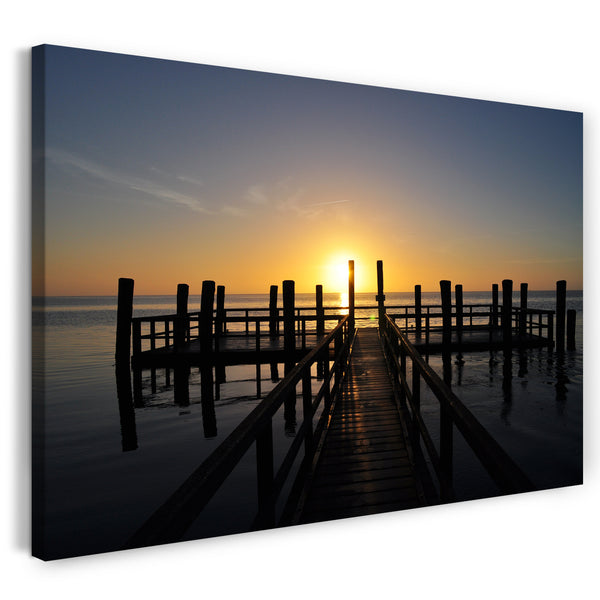 Leinwandbild Holzsteg im Meer unter aufgehender Sonne