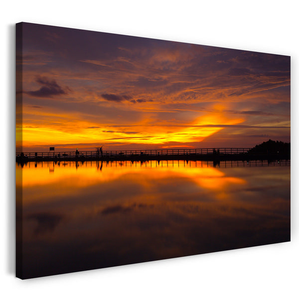 Leinwandbild Sonnenuntergang rote Sonne über langen Steg im Wasser mit Spiegelung